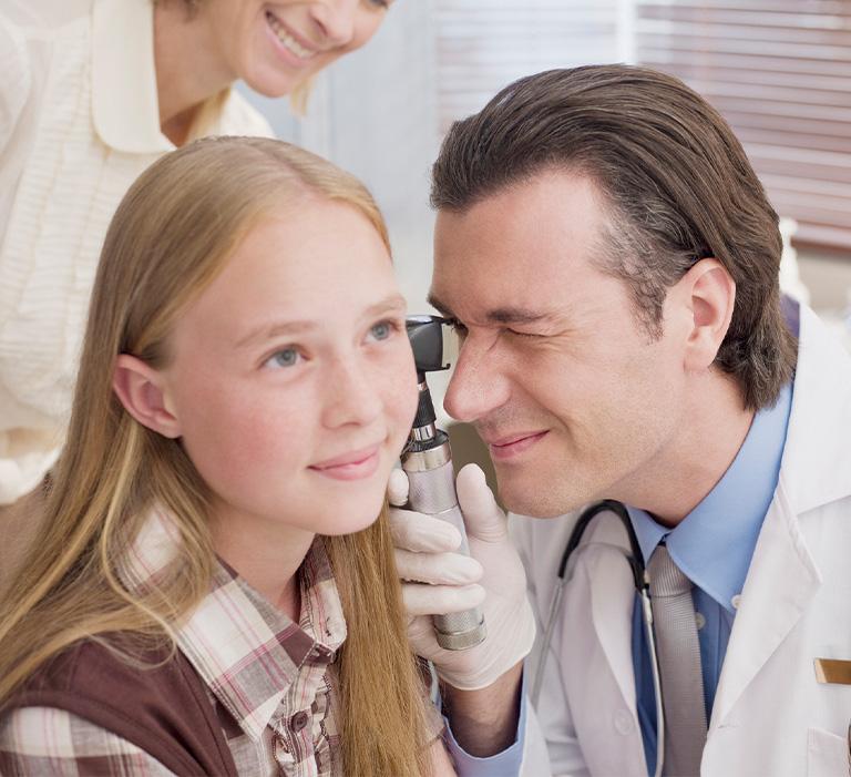 Doktor badający ucho dziewczynki